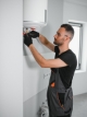 Heating engineer repairing a wall-mounted boiler